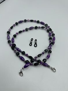 Handcrafted eye glass chain with lobster clasps and rubber glasses connector. Purple beads accented with black and silver beads are a perfect way to accent your glasses while keeping them with you. Have something different in mind, message me with special requests. Trendy Black Metal Glasses Chains, Black Metal Glasses Chain With Adjustable Feature, Black Metal Glasses Chains With Adjustable Chain, Black Metal Glasses Chain With Adjustable Length, Black Metal Adjustable Glasses Chain, Black Glass Beaded Jewelry, Elegant Black Metal Glasses Chains, Adjustable Black Metal Glasses Chains, Black Glass Beaded Necklaces With Beaded Chain