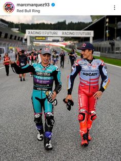 two men walking down the road with helmets on