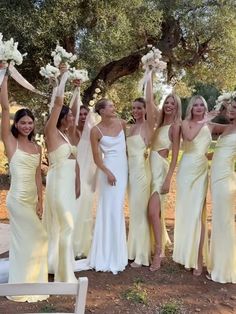 a group of women standing next to each other holding bouquets in front of them