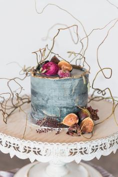 a cake with figurines and dried flowers on top