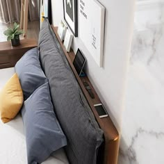 a bed that has some pillows on top of it and pictures above the headboard