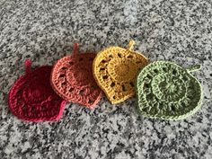 three crocheted potholders sitting on top of a granite counter next to each other