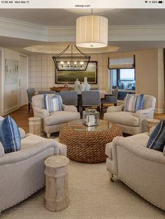 a living room filled with furniture and a chandelier hanging over the top of it