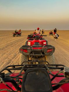 several people riding four wheelers in the desert