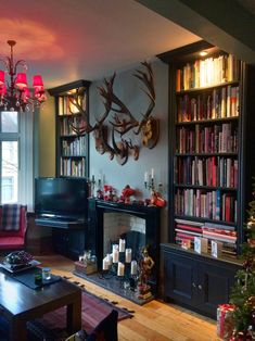 a living room filled with furniture and a christmas tree in front of a fire place