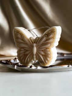 a butterfly shaped candle sitting on top of a plate