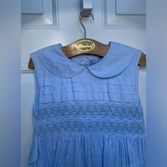 - Beautiful Hand Smocked And Embroidered Strasburg Dress - Excellent Like New Condition - Peter Pan Collar - Lined - 100% Cotton - Ties In Back - 41” Long - 13” Armpit To Armpit Blue Embroidered Dress, Hand Smock, Pan Collar, Peter Pan Collar, Embroidered Dress, Kids' Dresses, Beautiful Hand, Peter Pan, Smocking