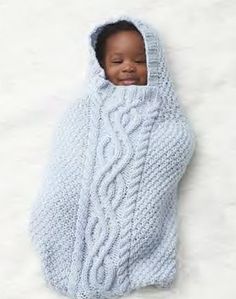 a baby wrapped in a blue blanket with the caption cake baby sack knitt