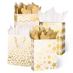 three gold and white gift bags with tissue paper