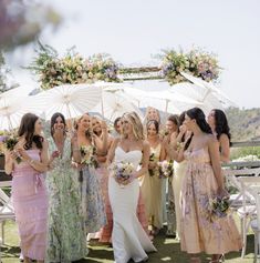 a group of women standing next to each other in front of an umbrella covered area