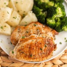 two pieces of chicken on a plate with potatoes and broccoli