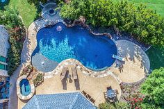 an aerial view of a pool surrounded by trees