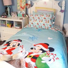 a bed with mickey and minnie mouse sheets on it