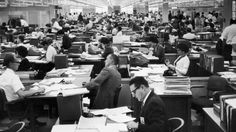 an office filled with lots of people sitting at desks