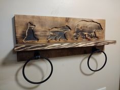 two metal rings are hanging on a wooden shelf with bear and polar bears in the wood