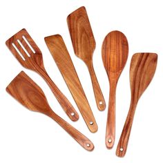 six wooden utensils are lined up on a white surface