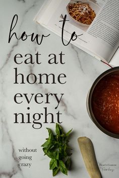 the book how to eat at home every night is next to a bowl of spaghetti