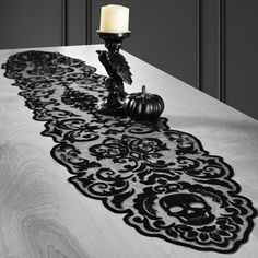 a candle is sitting on top of a table with a black and white lace runner