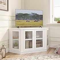 a flat screen tv sitting on top of a white entertainment center next to a window