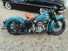 a blue motorcycle parked next to a black car