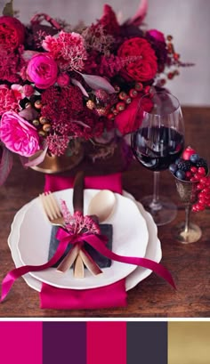 the table is set with pink flowers and plates, wine glasses, and napkins