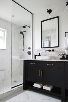 a black and white bathroom with marble counter tops