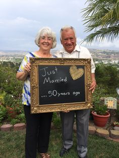 an older man and woman holding up a sign that says just married 50 years ago