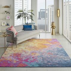 a living room filled with furniture and a large rug on top of a hard wood floor