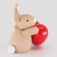 a wooden toy rabbit with a red heart on it's back, sitting against a white background