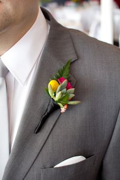 a man wearing a suit and tie with a boutonniere on his lapel