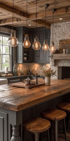 a kitchen island with stools and lights hanging from it's ceiling over the stove