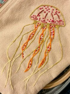 a close up of a piece of cloth with a jellyfish embroidered on the front