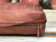 a brown leather bag sitting on top of a table