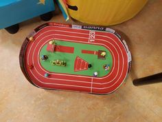 a toy race track on the floor next to toys and other items in a playroom