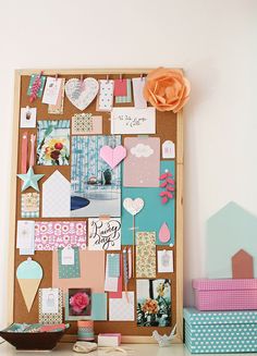 a cork board with many different things on it and a flower in the corner next to it