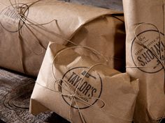 some brown paper wrapped in twine on top of a wooden table next to each other