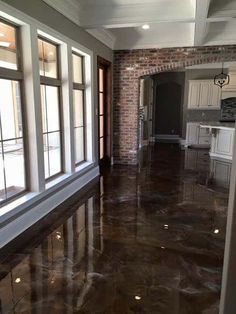 an empty living room with large windows and marble flooring in the middle of it