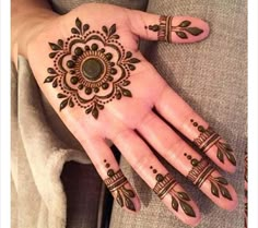 a woman's hand with henna tattoos on it