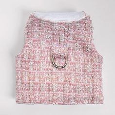 a pink and white tweed vest with a ring on the front