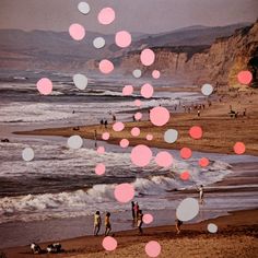 people are walking on the beach with pink and white confetti floating in the air