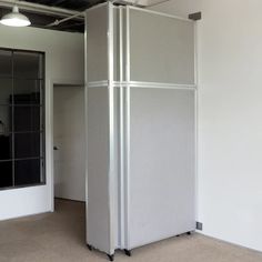 an empty room with white walls and metal partitions