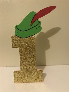 a gold glitter number one with a green frog sticking out of it