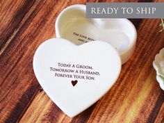 two white heart shaped dishes on top of a wooden table with the words today a groom, tomorrow a husband, forever your son