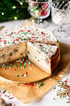 a cake with white frosting and sprinkles on a wooden cutting board