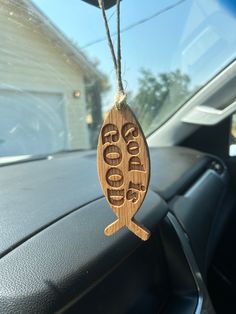 a wooden sign hanging from the side of a car's dash board that says go good