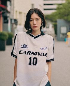 a woman standing on the street wearing a jersey