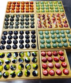 four wooden boxes filled with lots of different colored candies