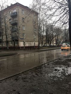 a wet street with cars parked on the side