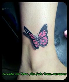 a pink and black butterfly tattoo on the ankle