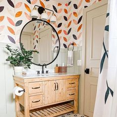 a bathroom with a sink, mirror and towel rack on the wall next to it